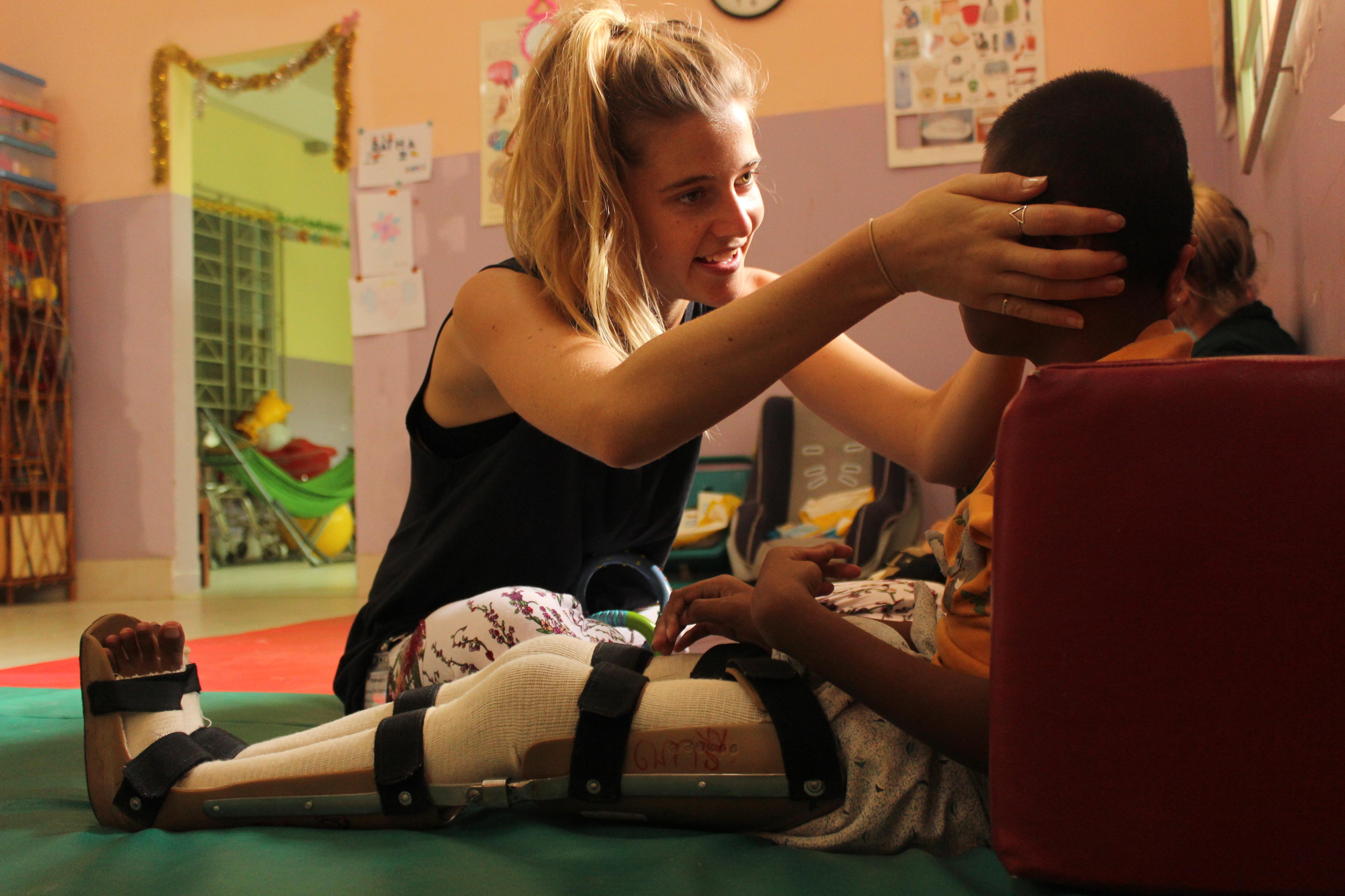 A female intern from Projects Abroad helping a young child during her physiotherapy internship in Cambodia. Projects Abroad intern helping a child as part of her physiotherapy internship in Cambodia.